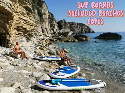 a group of people sitting on a rocky beach with surfboards at FREEDOM HOSTEL in Budva