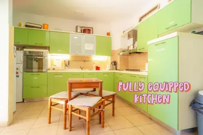 a kitchen with green cabinets and a table and chairs at FREEDOM HOSTEL in Budva