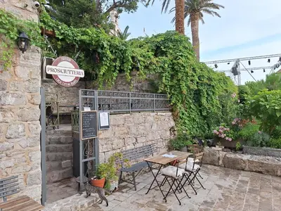 a patio with a table and chairs and a sign at FREEDOM HOSTEL in Budva