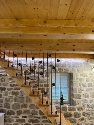 a staircase in a stone house with a chandelier at Casa Vecchia in Kotor