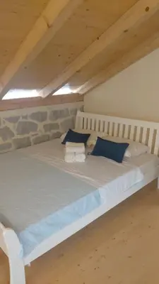 a white bed with blue pillows in a room at Casa Vecchia in Kotor