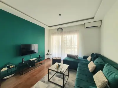 a living room with a green couch and a tv at Apartman Ana Lux in Podgorica