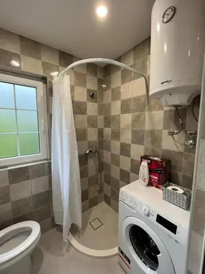 a bathroom with a washing machine and a shower at Dolce Casa in Kotor