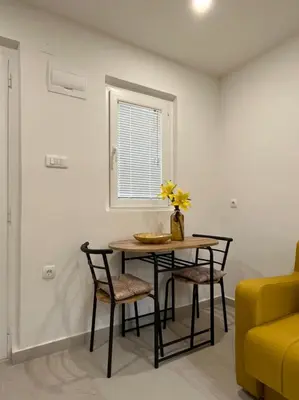 a dining room table with chairs and a vase with flowers at Dolce Casa in Kotor