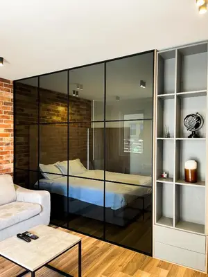 a bedroom with a bed in a glass wall at Anja & Ogo apartments with Pool _ in Petrovac na Moru