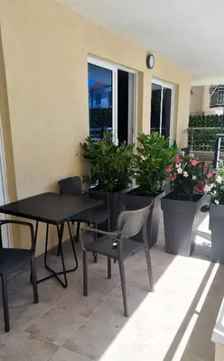 a patio with tables and chairs and potted plants at Anja & Ogo apartments with Pool _ in Petrovac na Moru