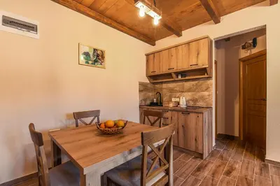 a kitchen and dining room with a wooden table and chairs at Lake Valley in Virpazar