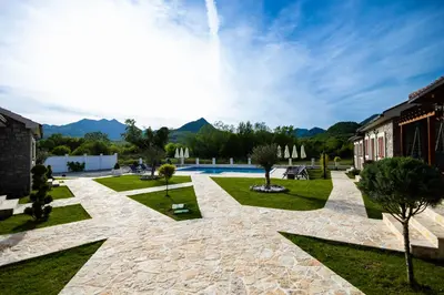 a courtyard with a pool and trees and a building at Lake Valley in Virpazar
