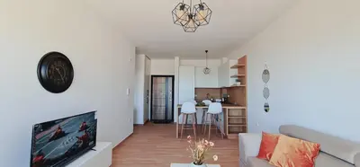 a living room with a couch and a tv at SeaView Apartment & Pool in Ulcinj