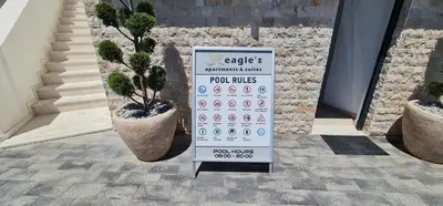 a sign in front of a building with potted plants at SeaView Apartment & Pool in Ulcinj
