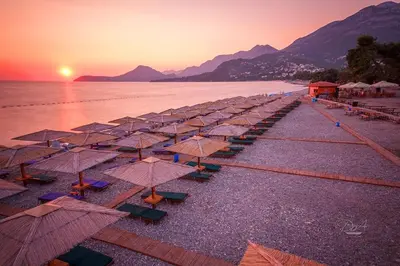 a row of umbrellas on a beach at sunset at DUBLIN STAN na dan u MARŠALA TITA in Bar