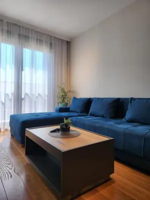 a living room with a blue couch and a coffee table at Green Apartments Podgorica With Garage in Podgorica
