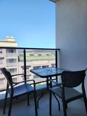 a table and chairs on a balcony with a view at Green Apartments Podgorica With Garage in Podgorica