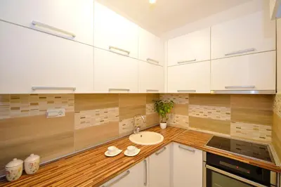 a kitchen with white cabinets and a sink at Apartment Filip in Kotor