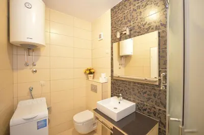 a bathroom with a sink and a toilet and a mirror at Apartment Filip in Kotor