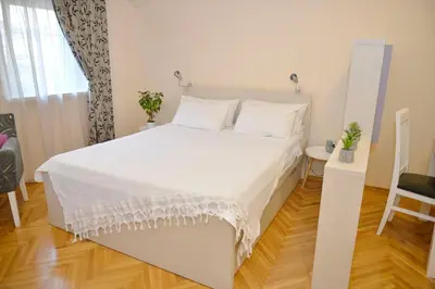 a bedroom with a large white bed with white sheets at Apartment Filip in Kotor
