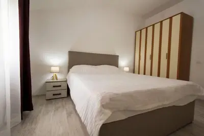 a bedroom with a large bed and a nightstand with two lamps at Eco Village experience - Skadar Lake in Virpazar