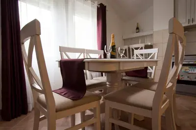 a kitchen with a table and chairs with a bottle of wine at Eco Village experience - Skadar Lake in Virpazar