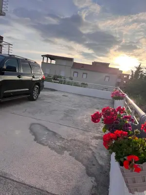 a van parked in a parking lot with flowers at ApartsDobraVoda in Dobra Voda