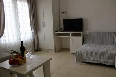 a living room with a table with a bottle of wine at ApartsDobraVoda in Dobra Voda