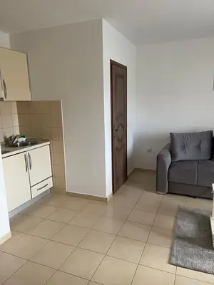 a living room with a couch and a kitchen at ApartsDobraVoda in Dobra Voda