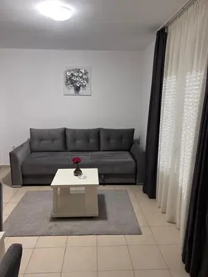 a living room with a couch and a table at ApartsDobraVoda in Dobra Voda