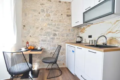 a kitchen with a table and chairs and a sink at Sambra old town apartment in Budva