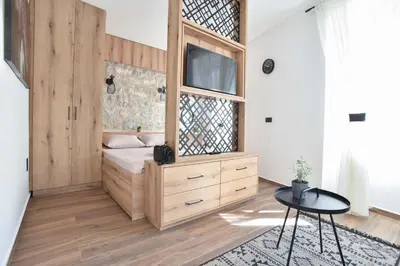 a bedroom with a bed with a window and a table at Sambra old town apartment in Budva
