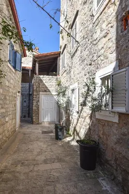 an alley in an old stone building with a white garage at Sambra old town apartment in Budva