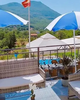 a balcony with benches and umbrellas with a view at Apartmani Dumezic in Bar