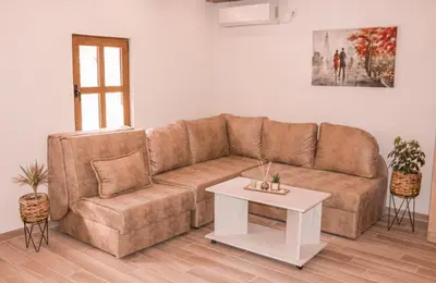 a living room with a brown couch and a table at Apartmani Dumezic in Bar