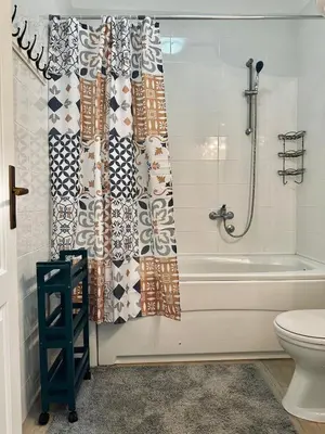 a bathroom with a tub and a shower curtain at Beach Bliss in Utjeha