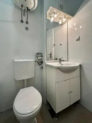 a white bathroom with a toilet and a sink at Beach Bliss in Utjeha