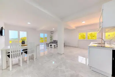 a kitchen and dining room with a table and chairs at Apartmani Panorama in Bar
