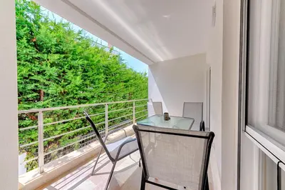 a balcony with a table and chairs and a window at Apartmani Panorama in Bar