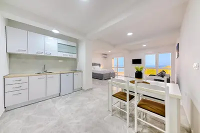 a kitchen with white cabinets and a sink at Apartmani Panorama in Bar