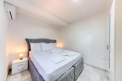 a small bedroom with a bed and a night stand at Apartmani Panorama in Bar