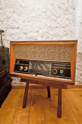 an old radio sitting on top of a wooden table at Sailor's Rustic House in Virpazar