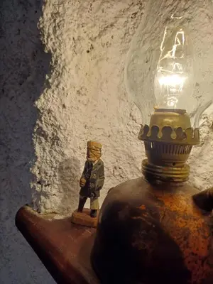 a lamp on top of a table with a small figurine at Sailor's Rustic House in Virpazar
