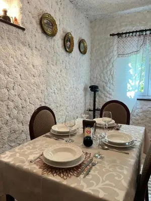 a table with plates and wine glasses on it at Sailor's Rustic House in Virpazar