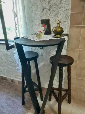 a wooden table with two stools and a bottle of wine at Sailor's Rustic House in Virpazar