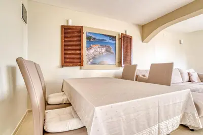 a dining room with a white table and chairs at SAVOVIC_LUX in Petrovac na Moru