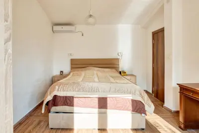 a bedroom with a bed in a white room at SAVOVIC_LUX in Petrovac na Moru
