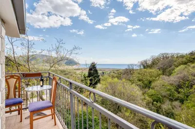 a balcony with two chairs and a view of the ocean at SAVOVIC_LUX in Petrovac na Moru