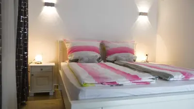 a bed with pink and white blankets and pillows at Lux Seky with Pool in Dobra Voda