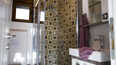 a bathroom with a shower with a sink and a glass shower door at Lux Seky with Pool in Dobra Voda