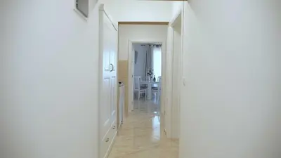 a white hallway with a dining room and a table at Lux Seky with Pool in Dobra Voda