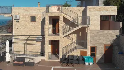 a brick building with stairs and tables and chairs at Lux Seky with Pool in Dobra Voda