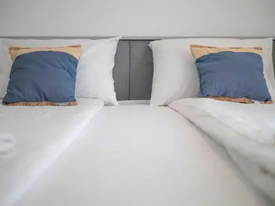 a bed with two blue pillows on it at Horizon-One bedroom apartment with pool Jane in Becici