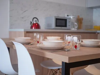 a wooden table with plates and glasses on it at Horizon-One bedroom apartment with pool Jane in Becici